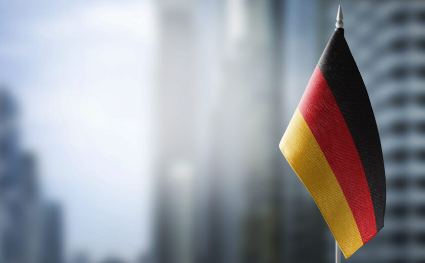 A small flag of Germany on the background of a blurred background